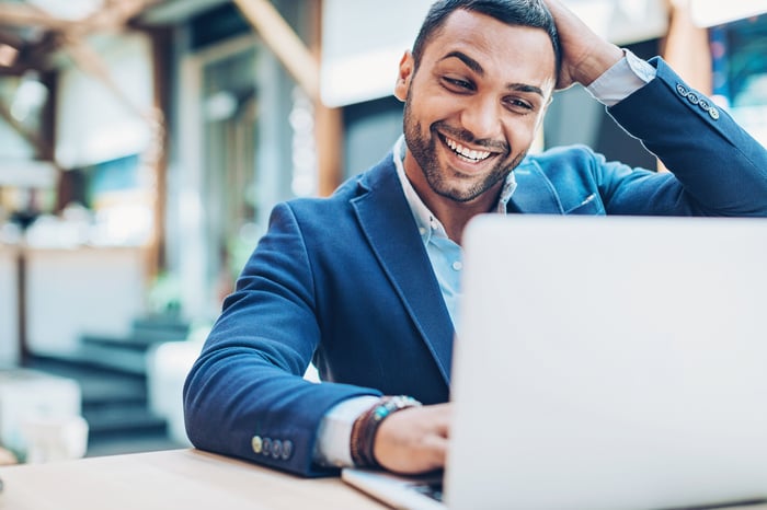 Excited businessperson looking at laptop.